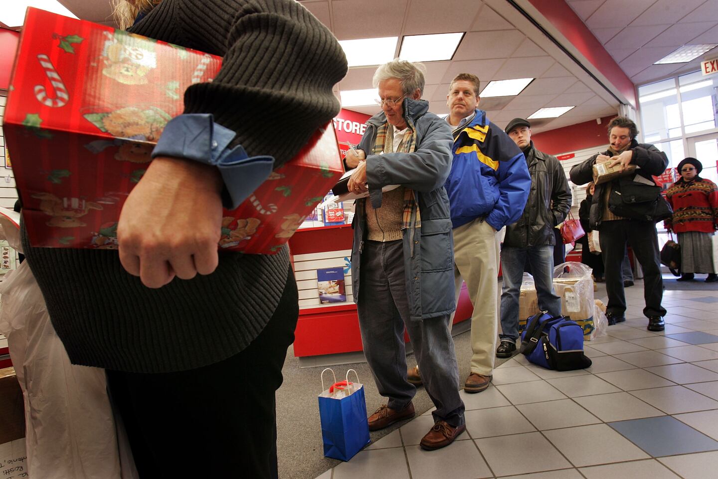 WASHINGTON - DECEMBER 20: U.S. Postal Service customers wait in line to mail Christmas presents at a U.S. Post Office December 20, 2004 in Washington, DC. The Monday before Christmas is the busiest day of the year for the U.S. Postal Service. The card and letter volume triples to about 280 million, sending the daily mail volume up to about 850 million pieces.