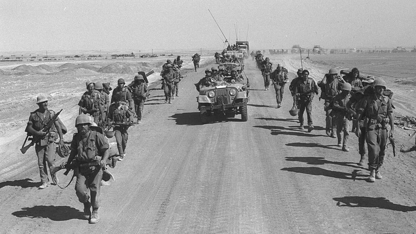 SUEZ-CAIRO ROAD, EGYPT -OCTOBER 25: (FILE PHOTO) Israeli paratroopers march October 25, 1973 along the Suez-Cairo road on the western bank of the Suez Canal during the Yom Kippur War. Current Israeli Prime Minister Ariel Sharon, then a general in the Israeli army, refused to rule out another surprise attack similar to the one launched by the Arab armies when they struck against Israeli troops in the Sinai Desert and Golan Heights on the holiest day of the Jewish calendar on October 6, 1973. (Photo by Ilan Ron/GPO/Getty Images)